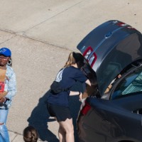 Birds Eye view of GVSU alumni helping new laker and her family unload luggage from car